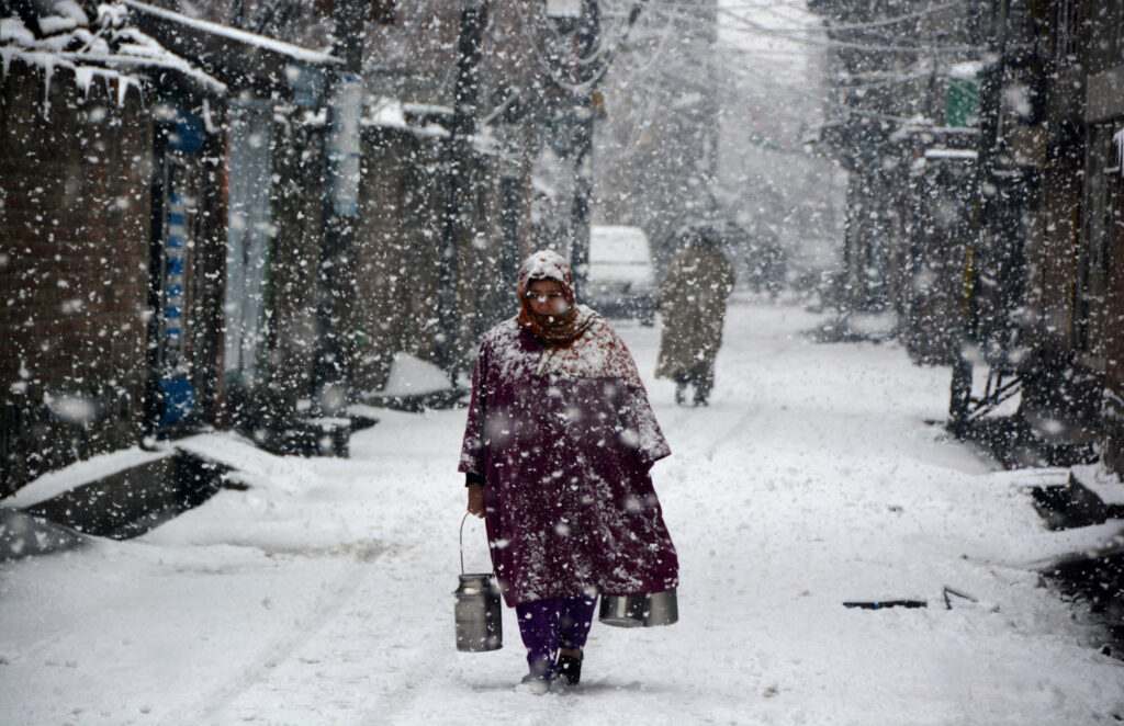 kashmir-a-woman-walks-along-with-milk-during-first-major-snowfall-in-srinagar-umar-ganie-09